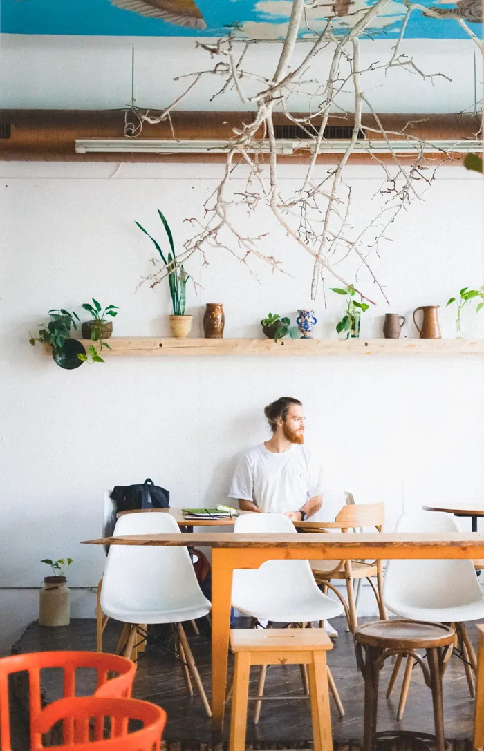 男人坐在房间内壁挂式架子下的椅子上