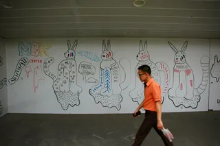 一个人走在白墙旁边