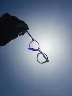 拿着玳瑁框眼镜的人