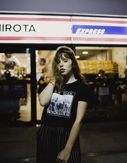 一名女子站在商店前的照片