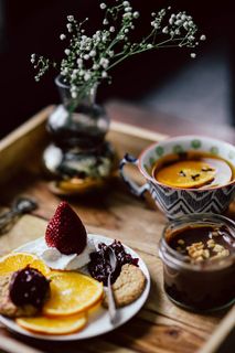 酒店早餐的客房服务托盘：饼干、果酱、巧克力慕斯、橘子水果、茶