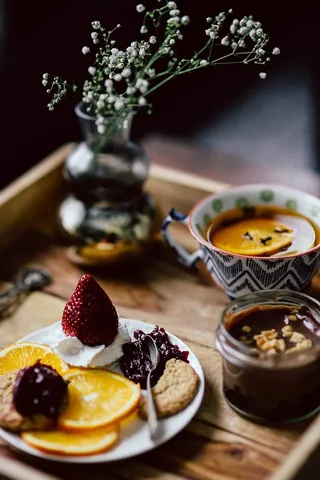 酒店早餐的客房服务托盘：饼干、果酱、巧克力慕斯、橘子水果、茶