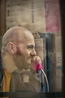 秃头男人把电话放在耳边