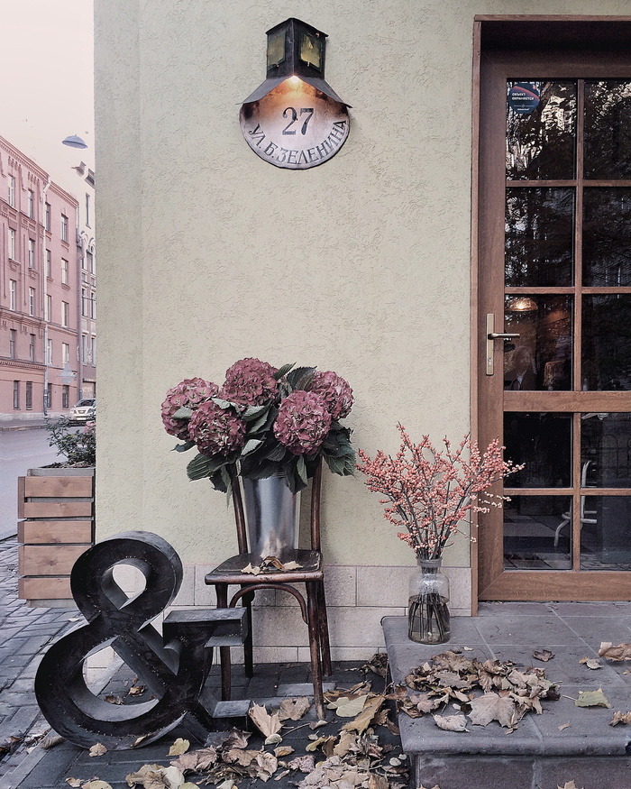 安装在米色混凝土墙上的黑白壁灯下的栗色花束