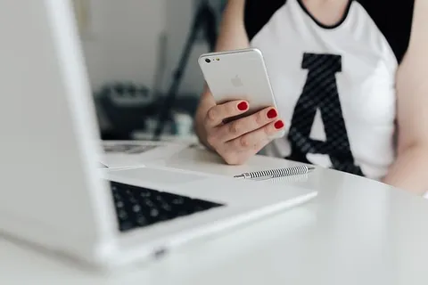 女商人在办公桌前使用手机 女商人在办公桌前使用手机