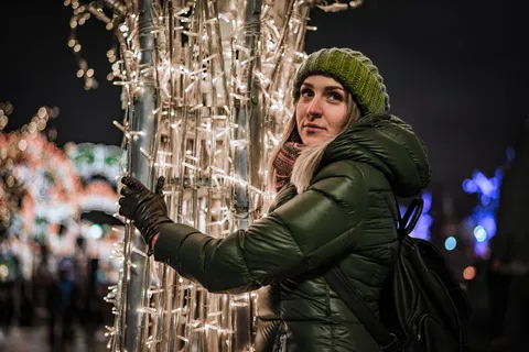 穿着泡泡夹克的女人抱着 LED 灯杆