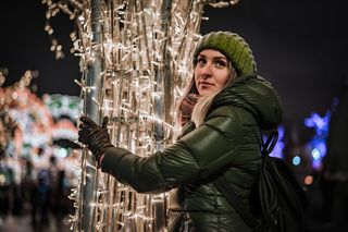 穿着泡泡夹克的女人抱着 LED 灯杆