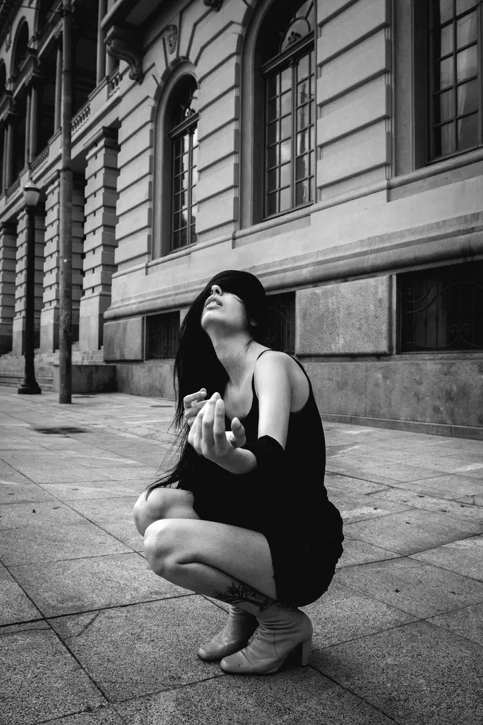 蹲在大楼附近人行道上的女人