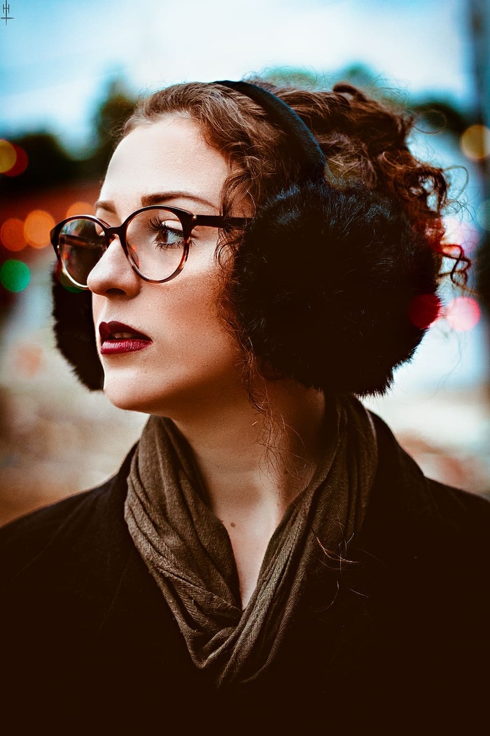 一张戴着黑色耳罩和眼镜的女子望向别处的照片