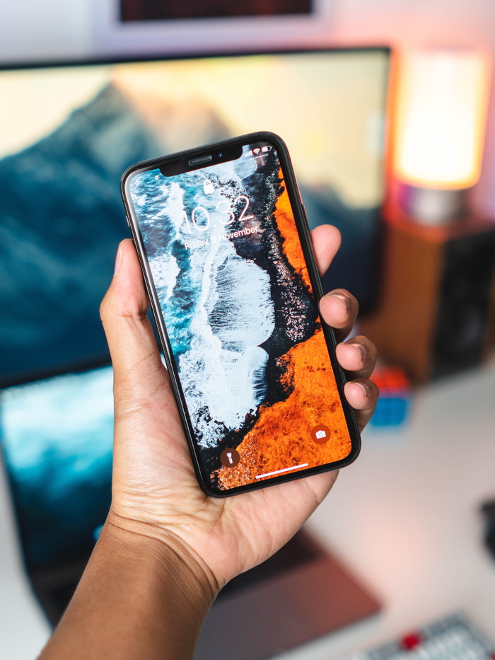 手持金色iPhone Xs的人