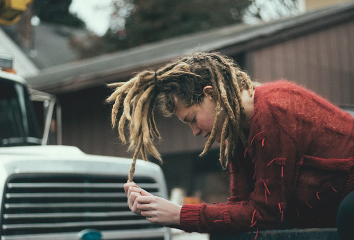 白色卡车旁穿着红色长袖衬衫的女子