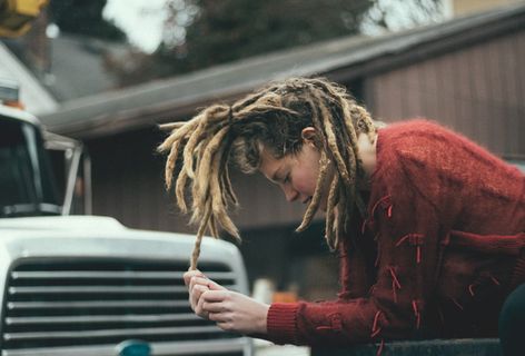 白色卡车旁穿着红色长袖衬衫的女子