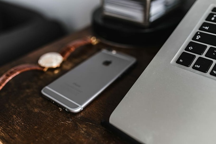 棕色皮夹上的苹果iPhone 6和复古手表