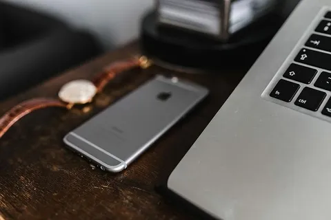 棕色皮夹上的苹果iPhone 6和复古手表 棕色皮夹上的苹果iPhone 6和复古手表