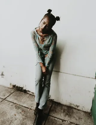 靠在白色油漆墙上的女人