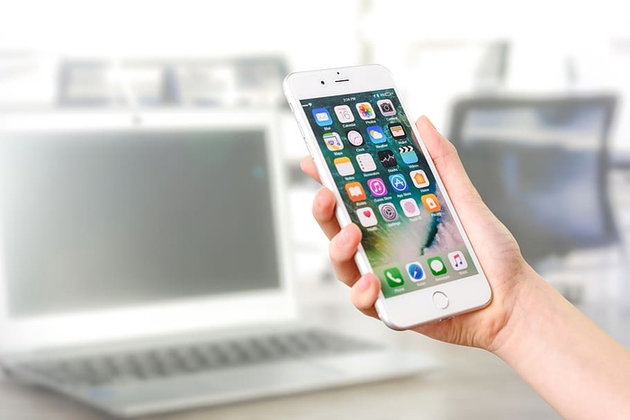 手持银色Iphone 7的人