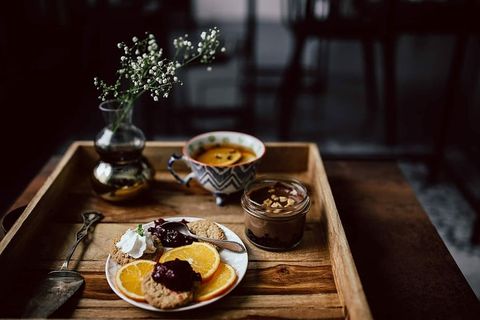 酒店早餐的客房服务托盘：饼干、果酱、巧克力慕斯、橘子水果、茶