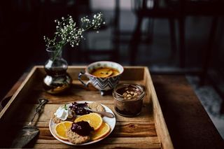 酒店早餐的客房服务托盘：饼干、果酱、巧克力慕斯、橘子水果、茶