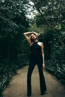 一名妇女站在树旁,同时抬起头 一名妇女站在树旁,同时抬起头