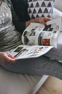 坐在沙发上看设计师杂志的女人