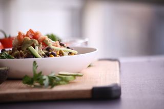 棕色木板上白色碗中的食物