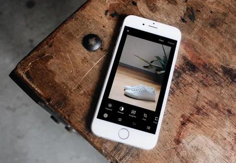 银色iPhone 6展示一双白色运动鞋 银色iPhone 6展示一双白色运动鞋