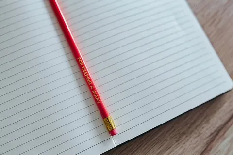 木制书桌上有彩色铅笔的笔记本