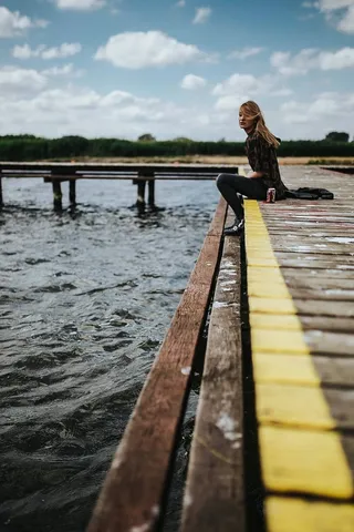 湖边一个木码头上美丽的金发女人