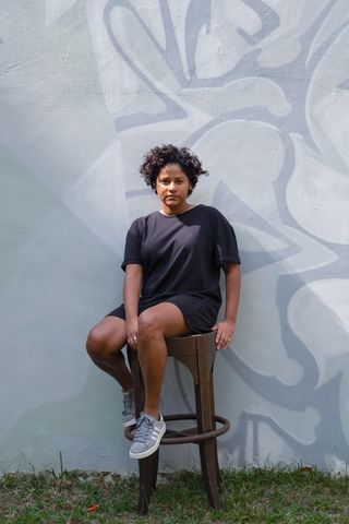 一个女人坐在一张棕色的圆木条椅上