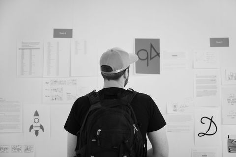 站着的人用别针纸看着墙上的灰度照片