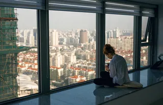 坐在玻璃墙上的女人