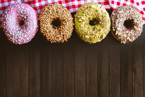木桌上放着四个很棒的美国甜甜圈