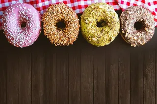 木桌上放着四个很棒的美国甜甜圈