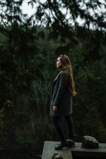 站在树旁混凝土壁架上的女人