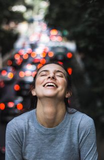 身着灰色长袖衬衫的微笑女子