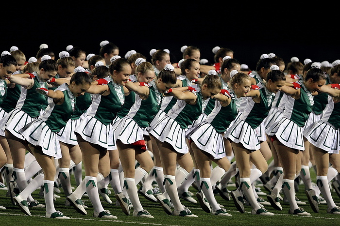 绿色草地上穿着绿色和灰色连衣裙的女孩