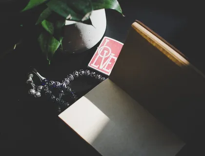 书籍和植物旁的银色米斯巴祈祷珠