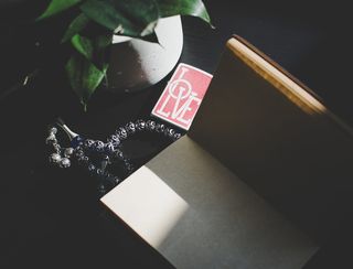 书籍和植物旁的银色米斯巴祈祷珠