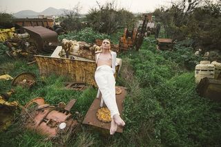 穿白色裤子的男子交叉双腿时躺在白色塑料凳子上