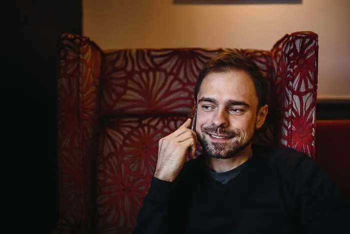 年轻的衣着优雅的男子坐在咖啡馆里