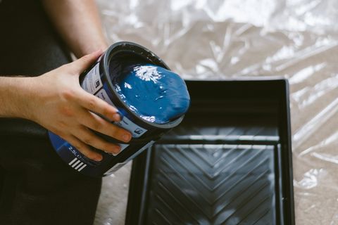 拿着蓝色油漆罐的人