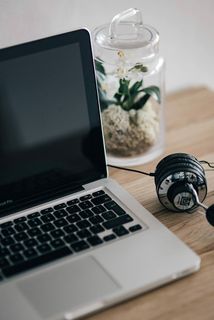 MacBook Pro在木制书桌上带耳机