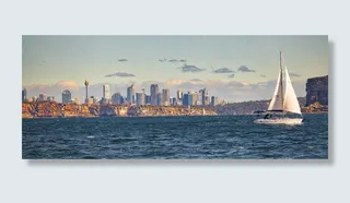 白色帆船在城市建筑物附近的水域航行