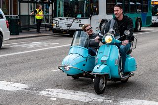 男子驾驶Teal摩托车，驾驶室和乘客在路上