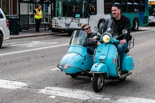 男子驾驶Teal摩托车，驾驶室和乘客在路上
