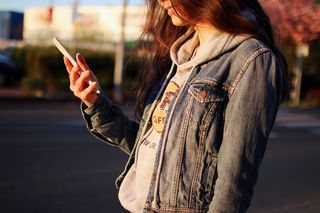 穿着蓝色牛仔夹克的女士日间摄影