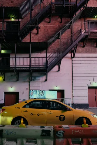 黄色轿车停在大楼前