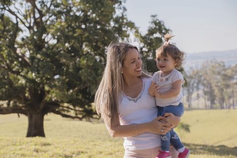 一位女士微笑着看着她的孩子的照片