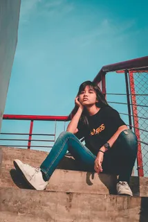 坐在室外灰色水泥楼梯上的女人 坐在室外灰色水泥楼梯上的女人