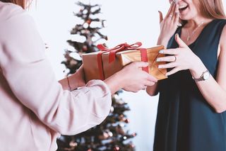 收到礼物的女人既高兴又惊讶。圣诞快乐